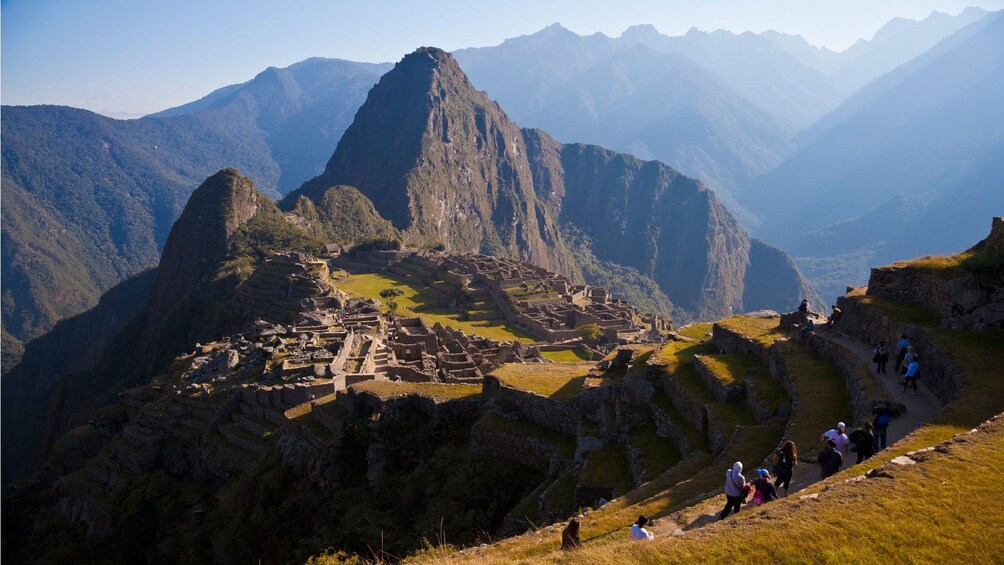 Tourists on a path in the mountains near ruins in Peru
