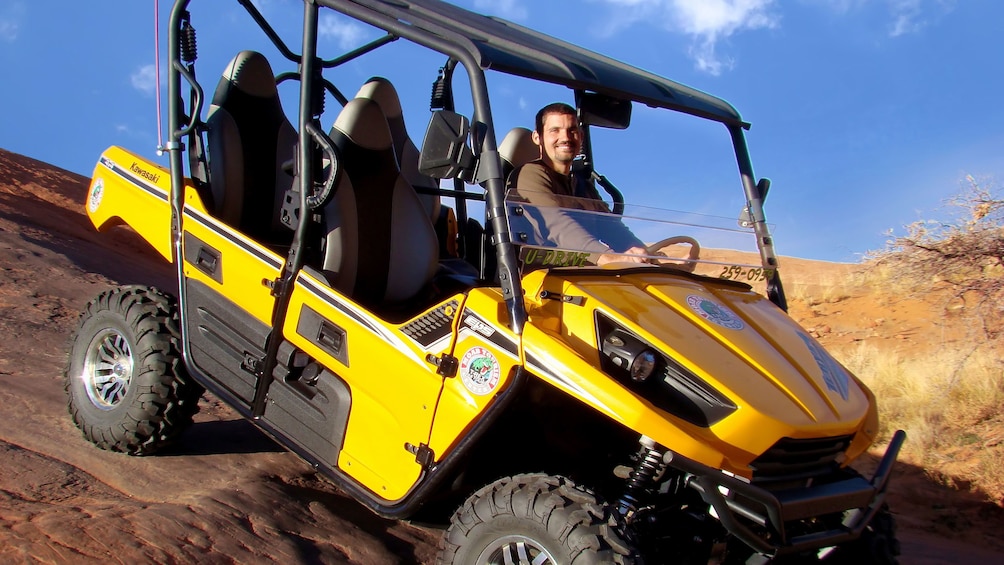 Show item 1 of 10. Man in ATV in the hills of Moab