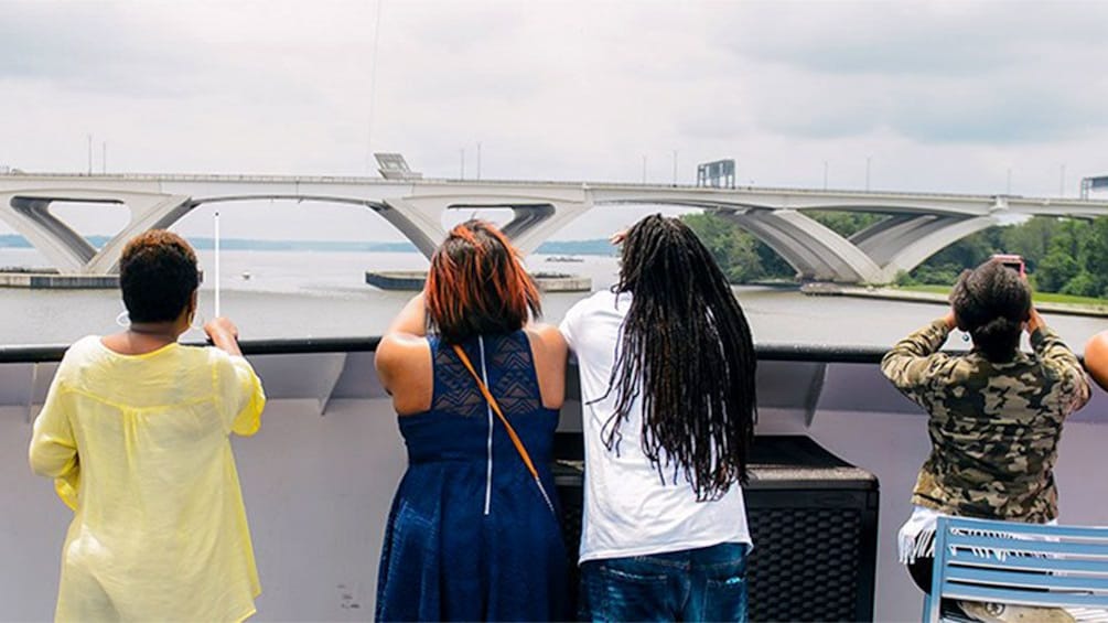 Passengers looking out at the sites from the deck of a cruise boat in Washington DC
