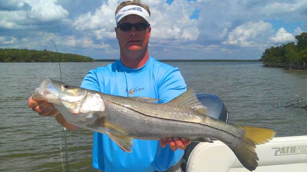 Show item 1 of 10. A man holding a fish