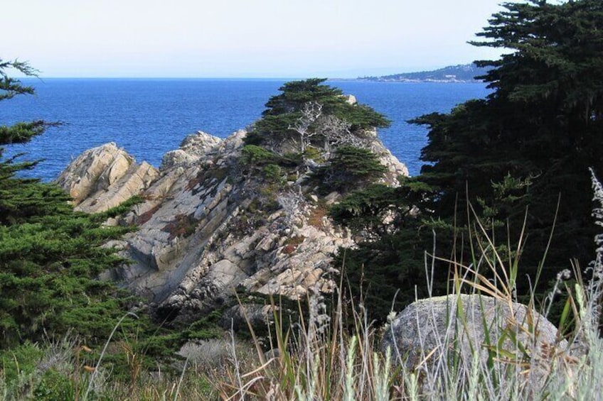 Uplifted granite formations jut out into Carmel Bay where you have a clear view of Pebble Beach across the water.