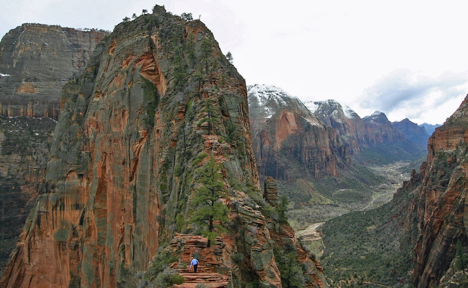 Hiker walking up rock formation in Zion National Park