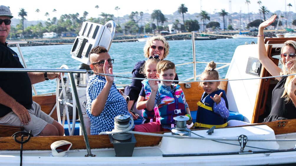 Family waving from boat in San Diego