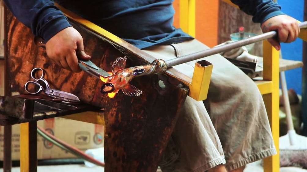 Glass maker working on glass fish in Los Cabos