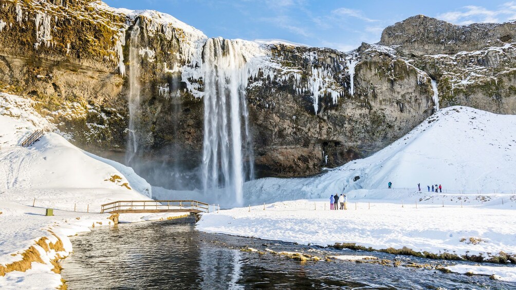 Tour group near a waterfall in the snow in Reykjavik