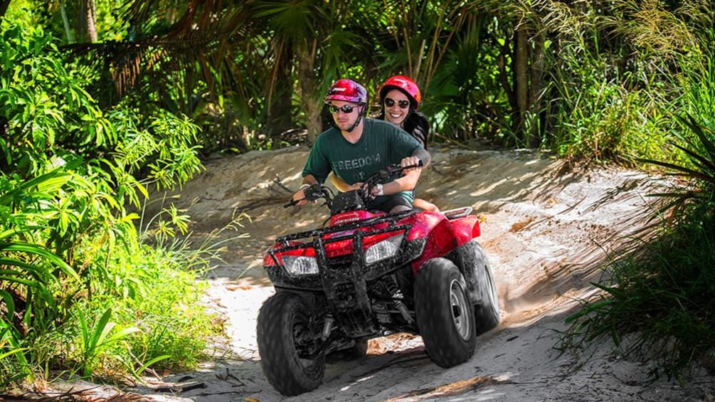 Two people on an ATV on a trail
