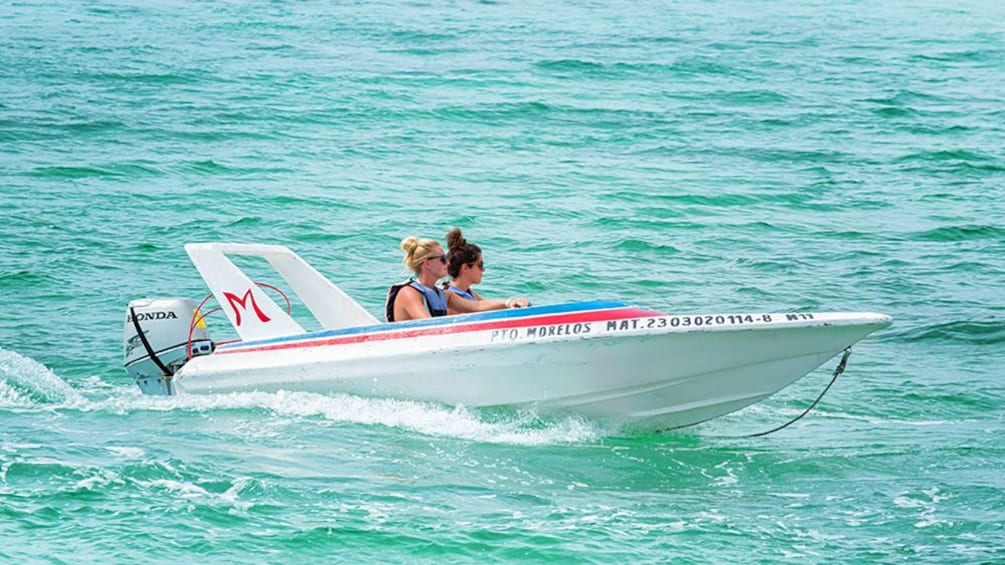 A speedboat of two people in Cancun