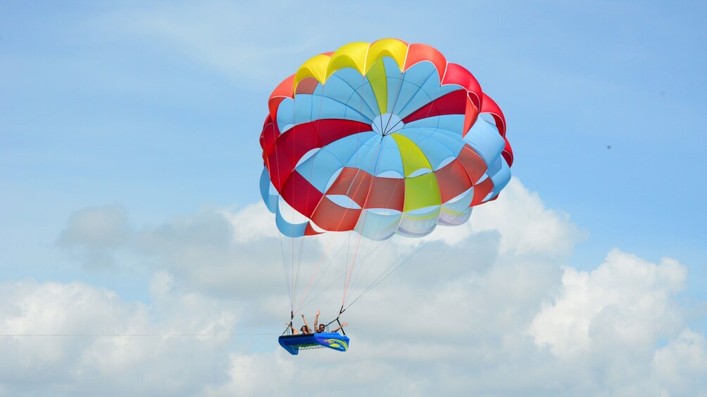 Sky Rider parasailing raft high in the air over the water in Cancun