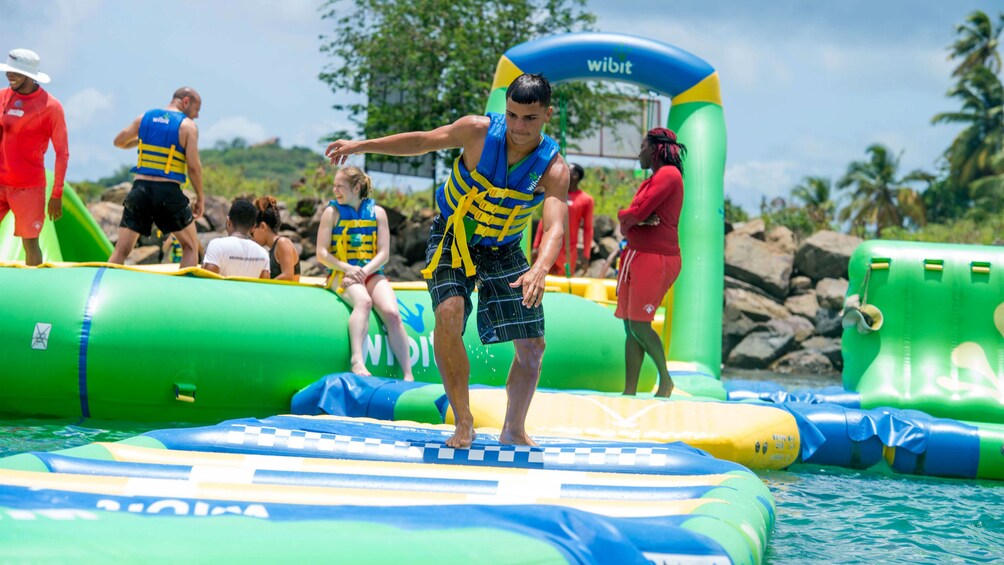 Young man running on a raft at a water park in St Lucia