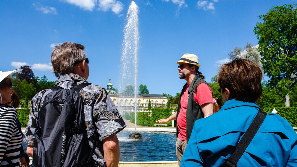 Show item 1 of 5. Tour guide and group at a fountain in Potsdam