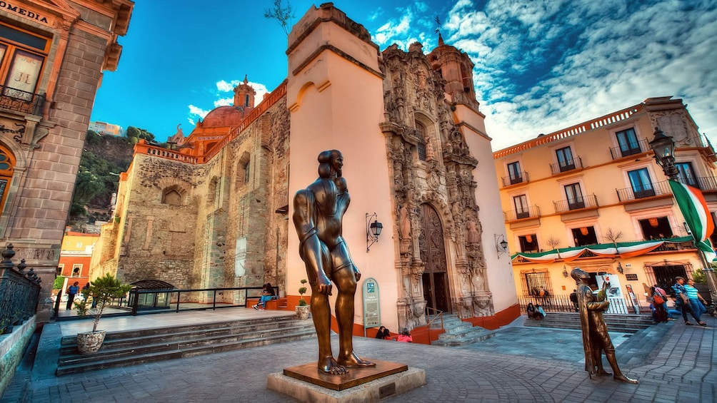 Brass statues with surrounding historical buildings in Guanajuato