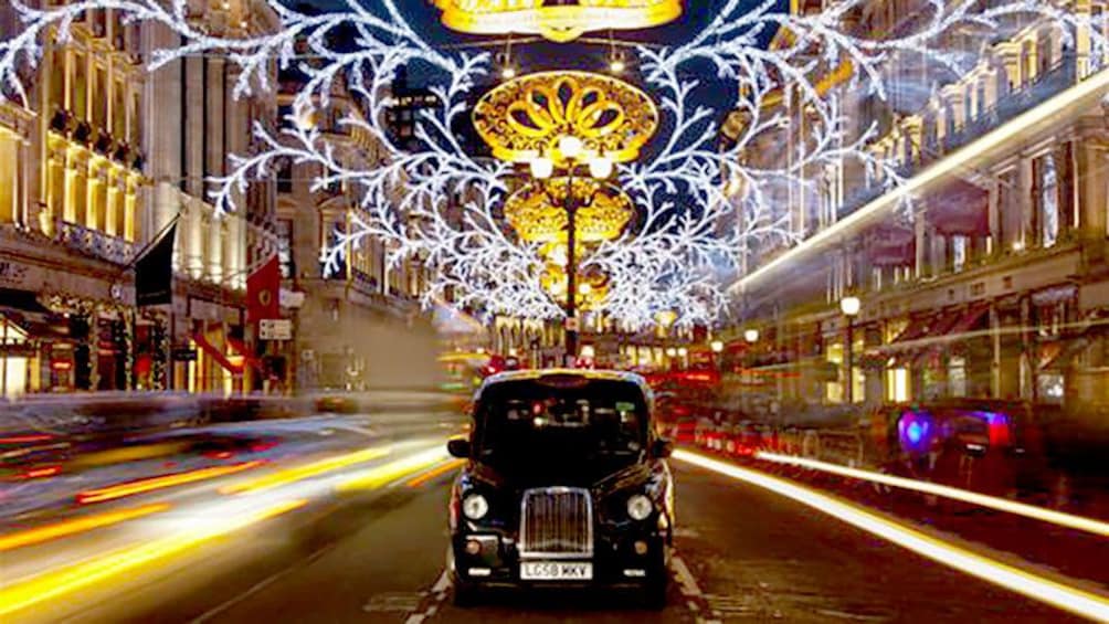 Rolls Royce in the middle of a street under xmas lights