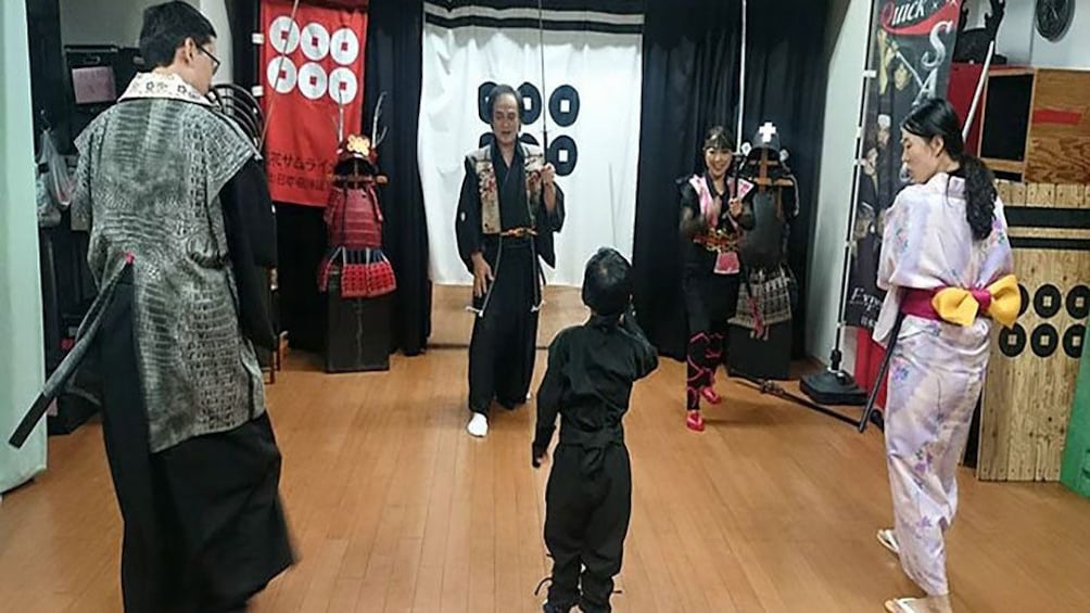 Show item 5 of 9. People in traditional Japanese clothing with swords in studio in Osaka