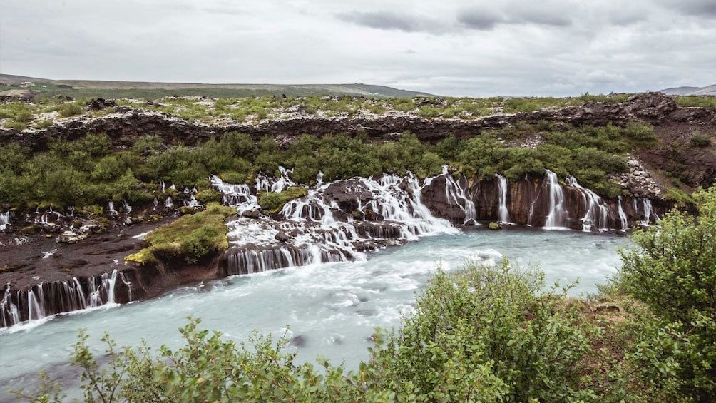 Waterfalls off of a cliff into a bay in Iceland