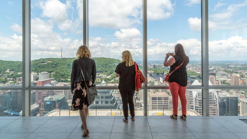 Three women look out at Montreal