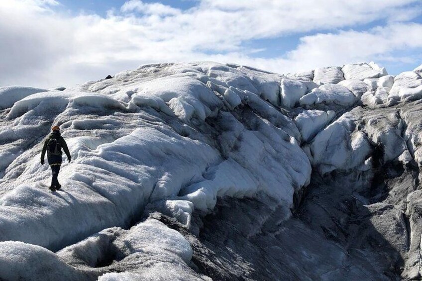 A solo glacier explorer upon Vatnajökull glacier, Iceland, on a sunny day.