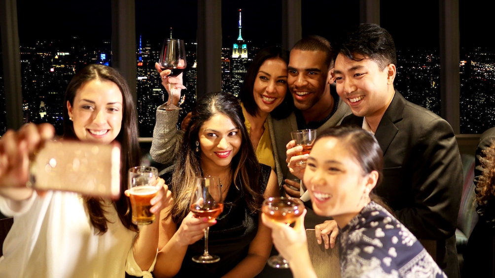 Show item 5 of 10. Group taking selfie during evening at One World Observatory in New York