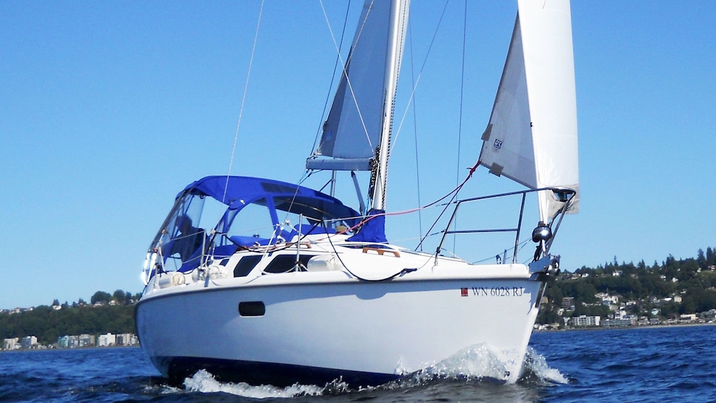 Close up of sailboat with wind in sails moving though the water of Puget Sound