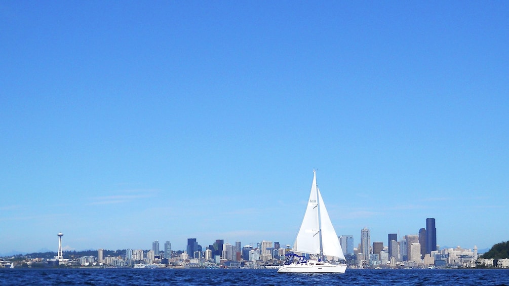 Wide view of sailboat and Seattle skyline in background in Puget Sound