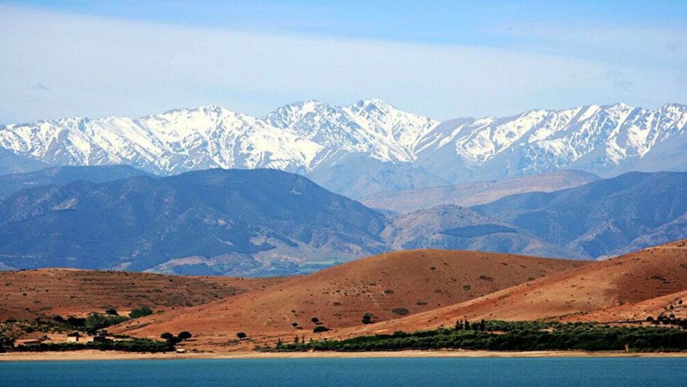 Sandy hills with snow covered mountain range in the background in 3 Valleys