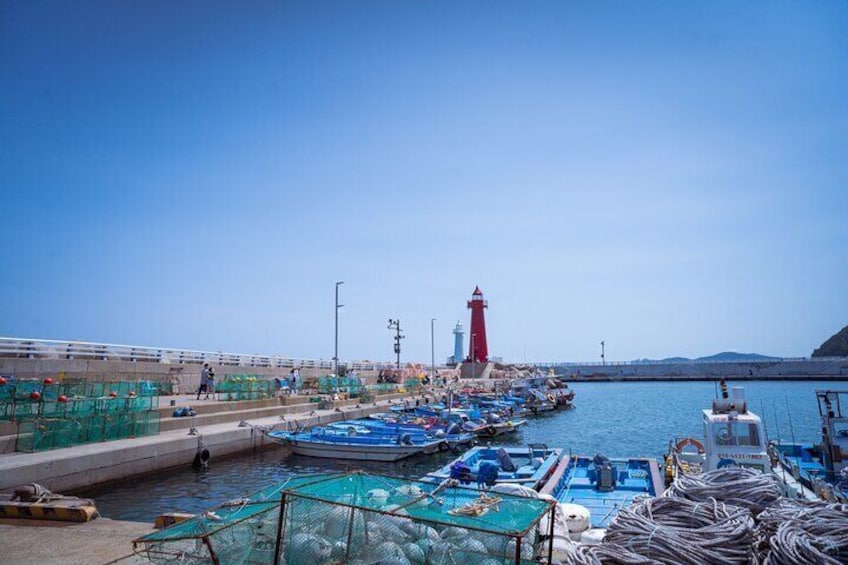 Cheongsapo Lighthouse and fishing boats at the Mipo Railroad Spot in Cheongsapo.