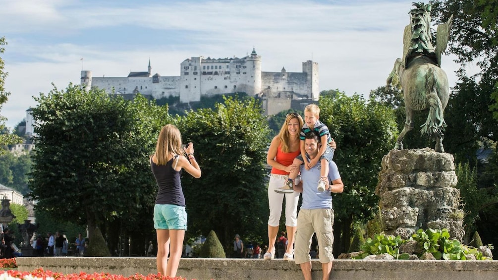 Foto 5 von 5 laden Family taking a photo next to a statue in Salzburg
