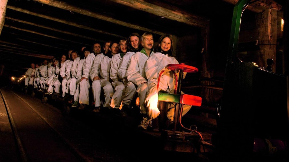 Show item 2 of 5. Tourists embark on a trolley ride through the salt mine