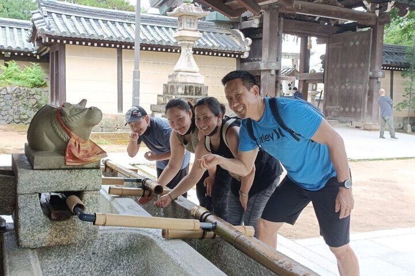Family enjoying Temizu at a shrine in one hot summer
