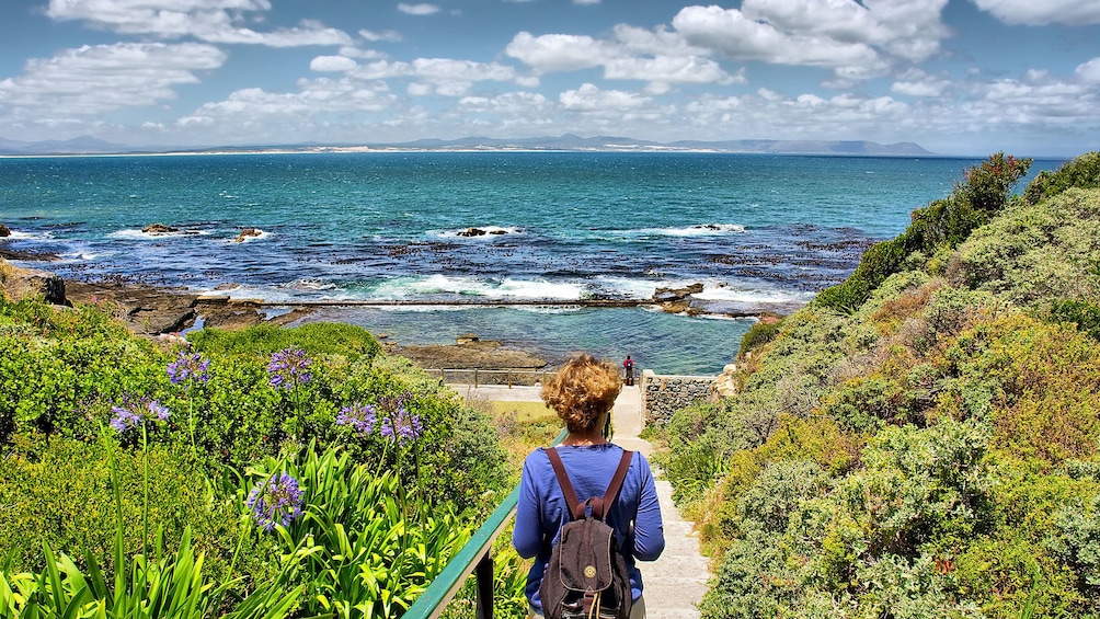 woman walking down foot path of Walker Bay in Hermanus