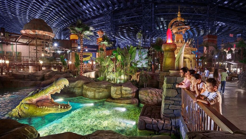 Family looks at giant animatronic alligator in IMG Worlds of Adventure 