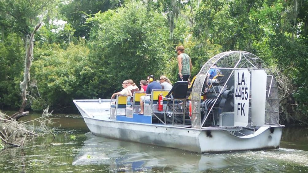 Airboat with tourist making way down creek in New Orleans