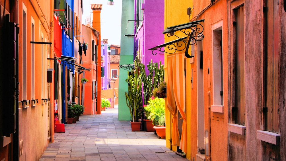 Sidewalk flanked by colorful buildings in Burano