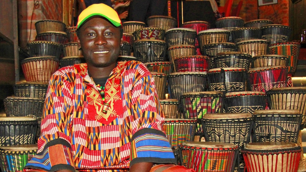 Man sits next to woven baskets