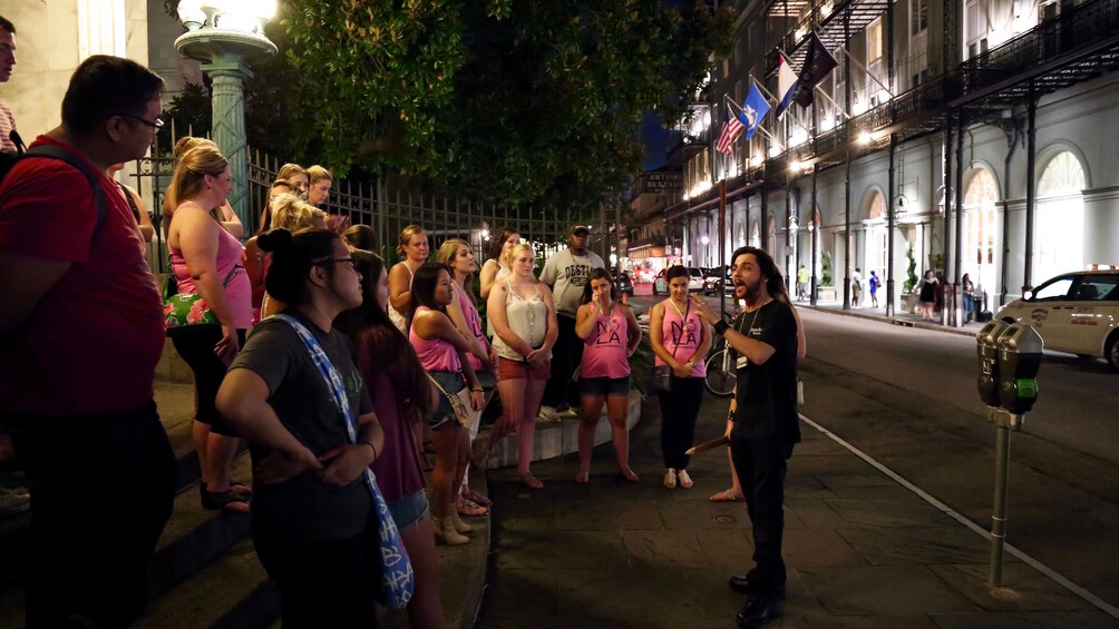 Tour guide talking to tourists at night in New Orleans