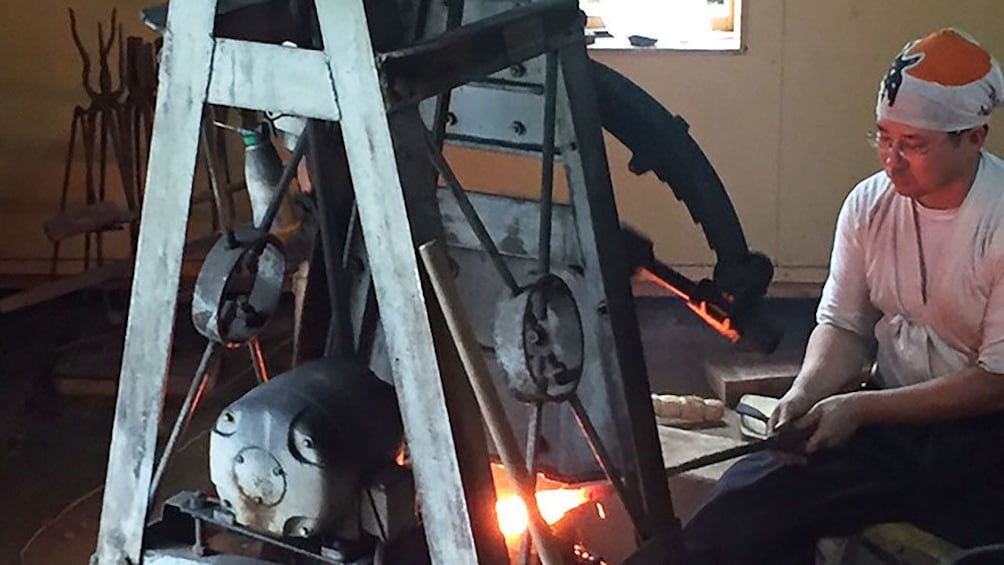 Blacksmith working on glowing hot piece of metal in Kyoto
