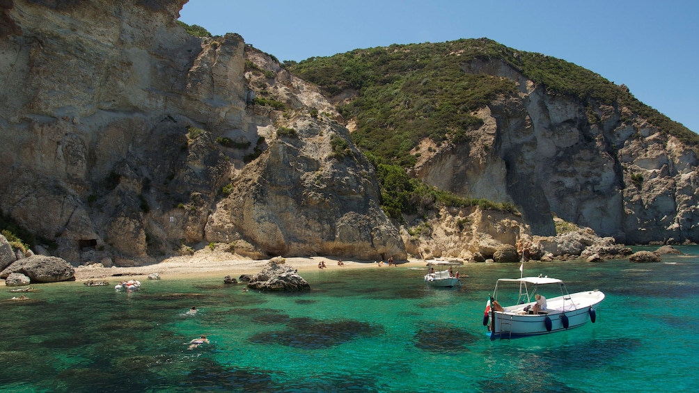 People swimming in bay with boat moored near by off Ponza Island