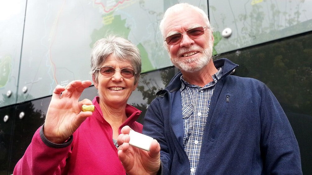 Older couple holding small pieces of gold in Waikato