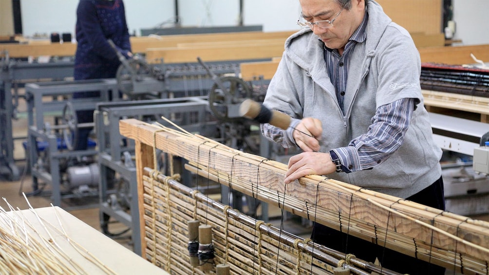 View of a man on the Kyoto style Kasumi Bamboo Mat Making tour 