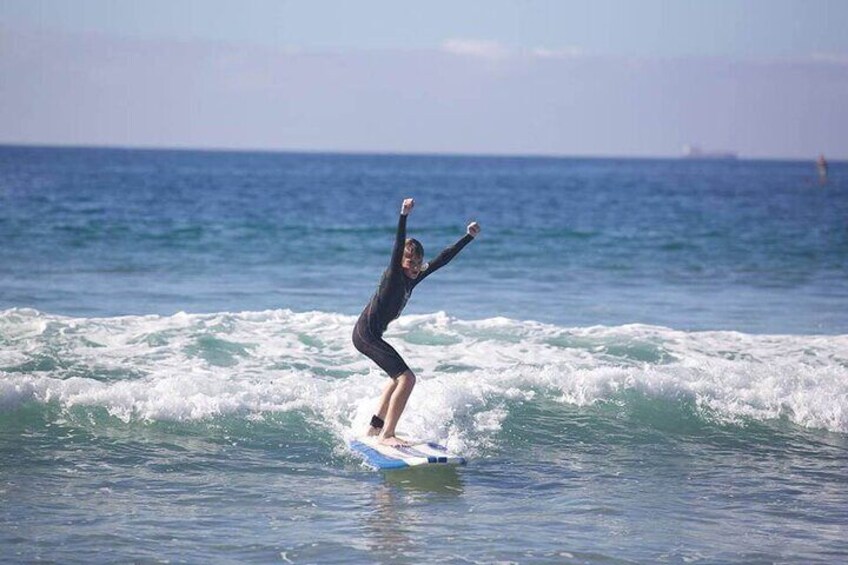 Boy cheers as he catches a wave