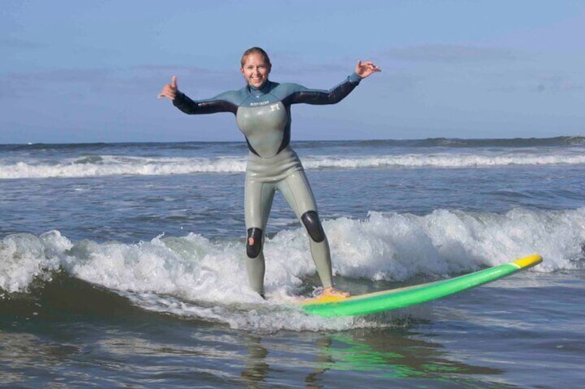 Woman rides a great wave into shore. 