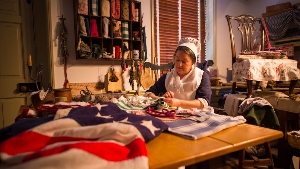 Charger l’élément 3 sur 5. Betsy Ross actress poses for photo while working on flag in home in Philadelphia