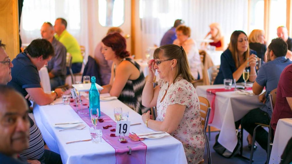Show item 3 of 8. People at dining tables on a cruise ship