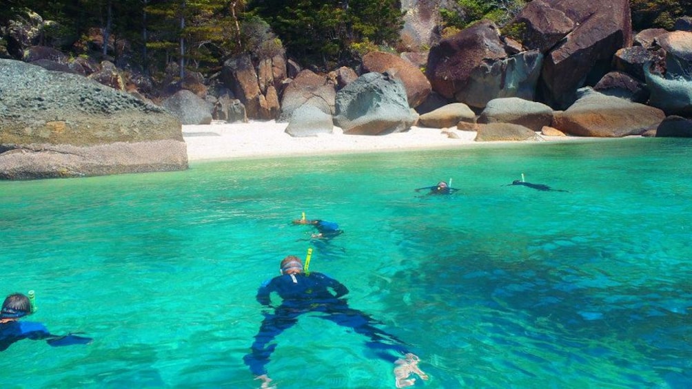 Show item 2 of 5. Snorkelers in a cove