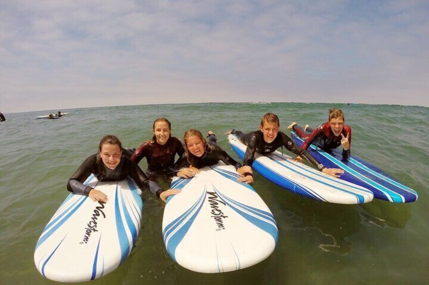 Teens paddle out during a group lesson. 