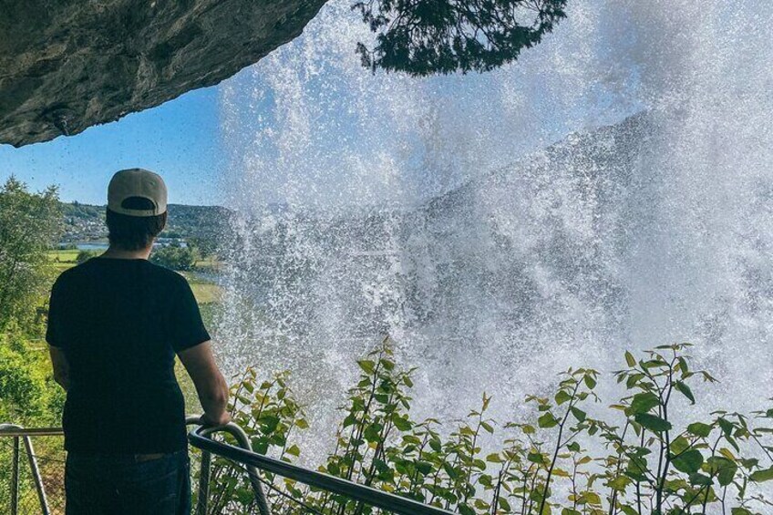 Enjoy the view while standing behind the waterfall