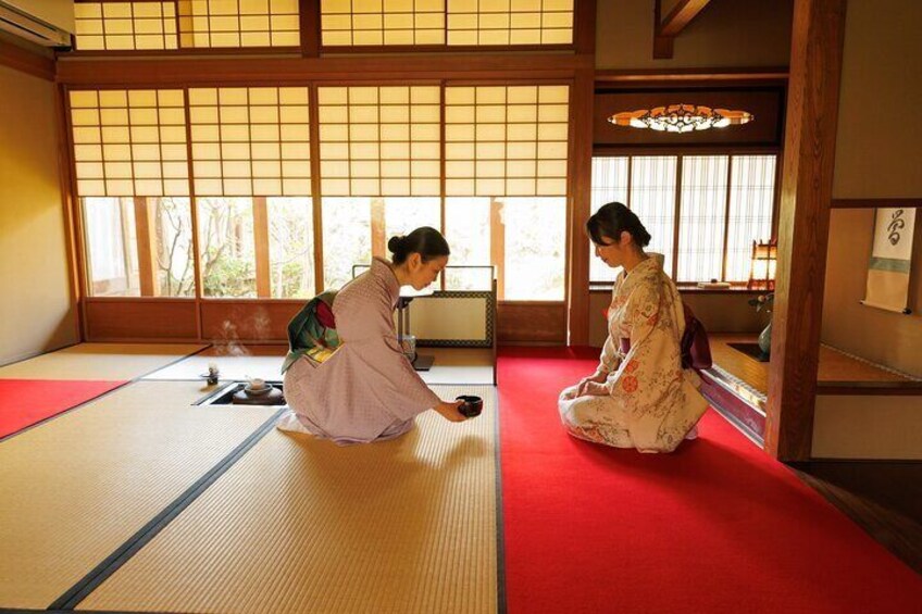 Serving tea to a guest at Garden Teahouse.