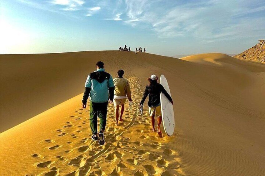 walking towards the hill for experiencing sandboarding 