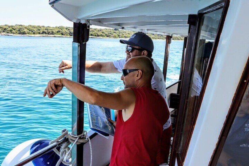 Tour guide showing traveler the famous fish shaped island (Gaz). It is also the logo of the national park Brijuni.