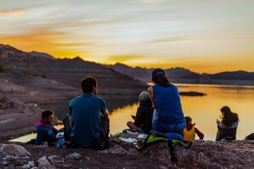 Guests eating snacks and watching the sunset on Lake Mead.