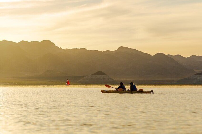 Guests in a tandem kayak at sunset on Lake Mead.